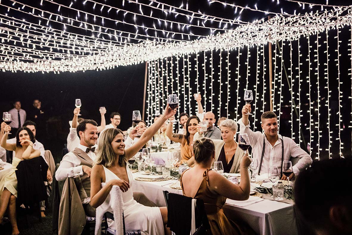"Alt"fotógrafo de bodas en España brindis con luces de fondo"