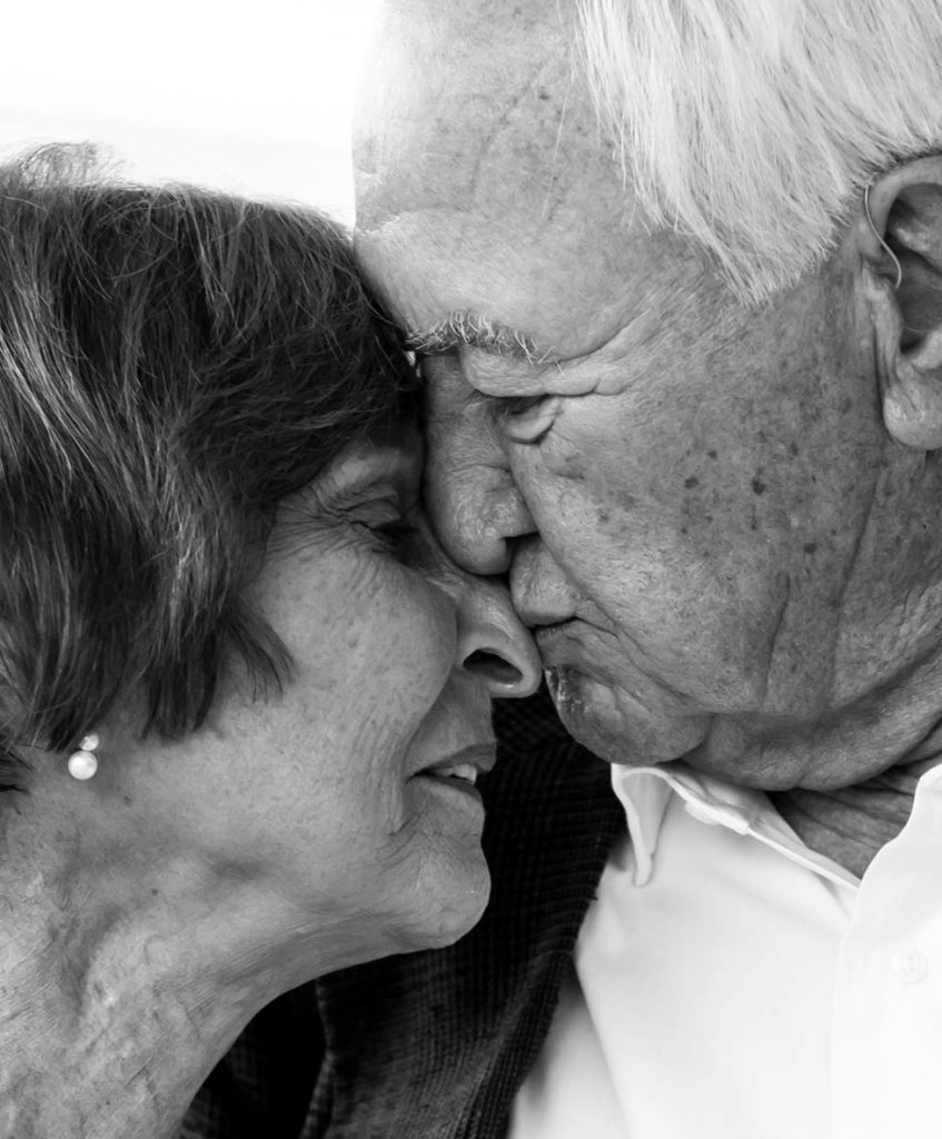 Pareja mayor compartiendo un momento íntimo durante la boda de su nieta, fotografiada por Inma del Valle