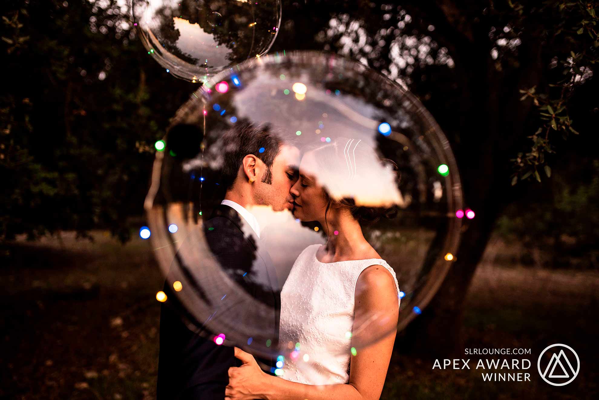Bride and groom sharing an intimate embrace at sunset after their wedding ceremony, surrounded by magical lights in Mallorca.