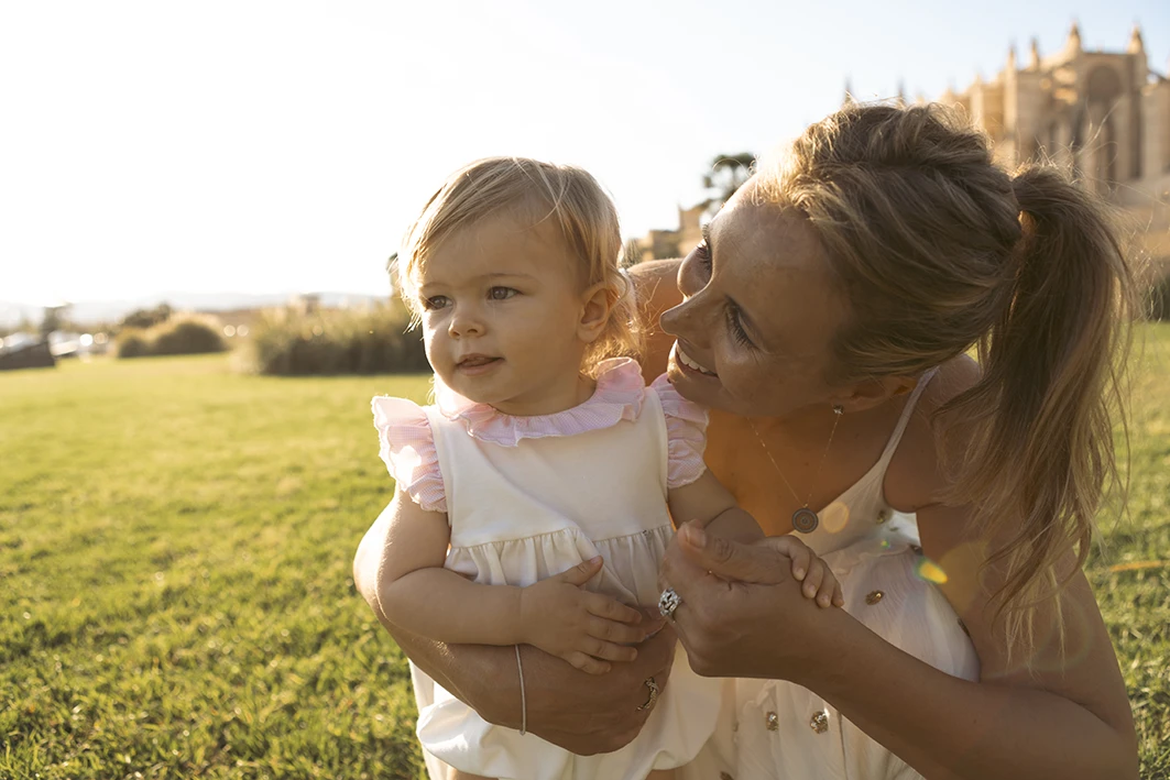 Madre abrazando a su hija durante una sesión de fotografía familiar en Mallorca en un entorno natural