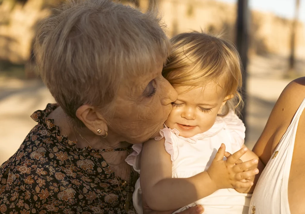 Abuela besando a su nieta durante una sesión de fotografía familiar en Mallorca