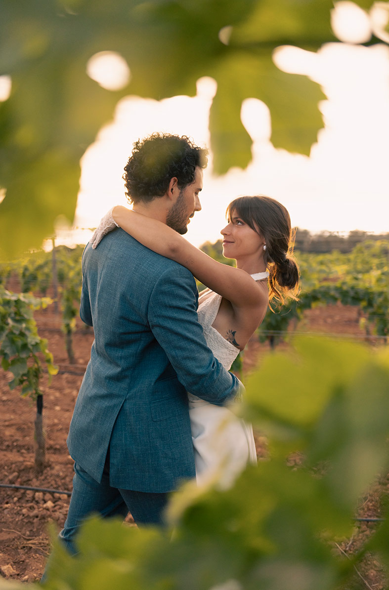 Pareja argentina abrazada entre viñedos durante su boda en Finca Gomera, fotografiada por Inma del Valle