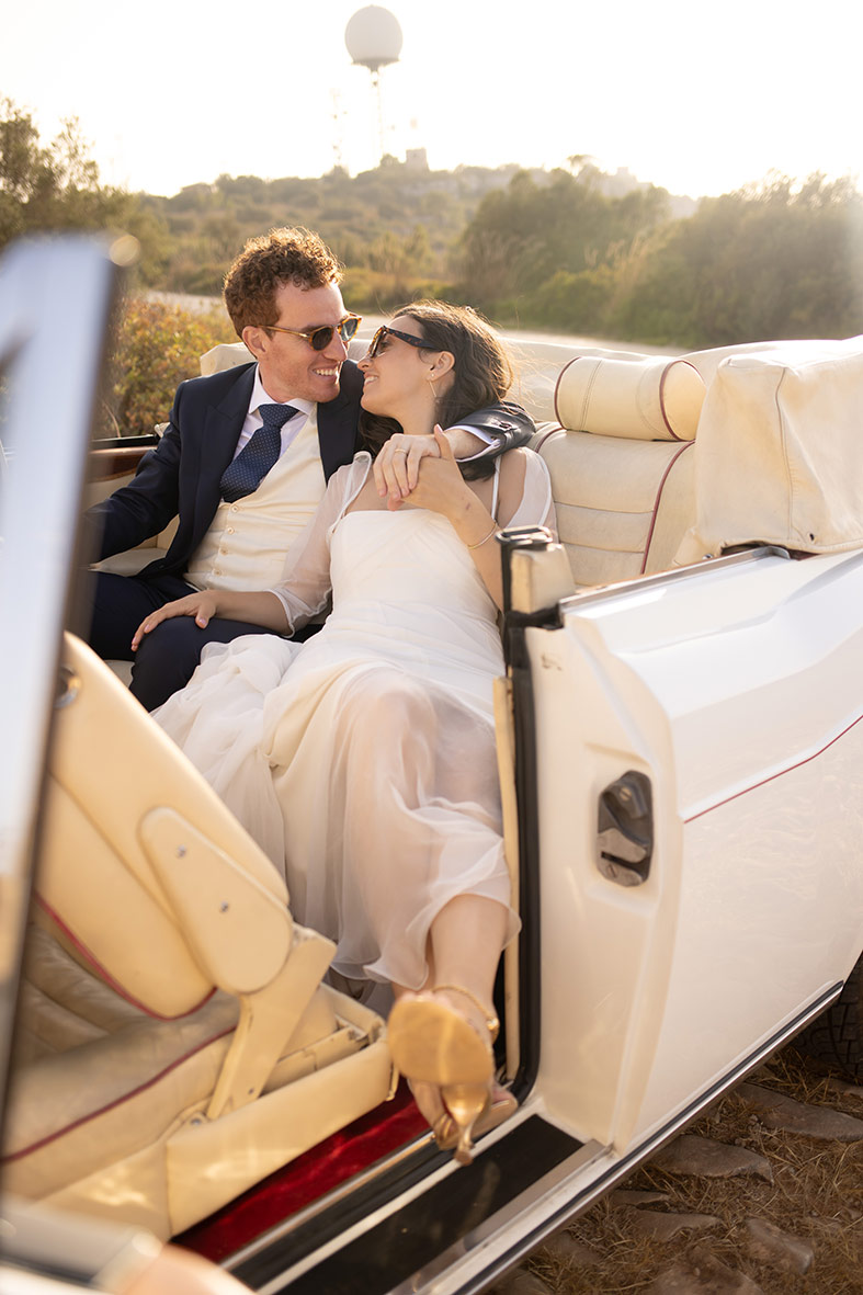 Pareja elegante besándose en un coche de lujo durante su boda en Mallorca fotografiada por Inma del Valle