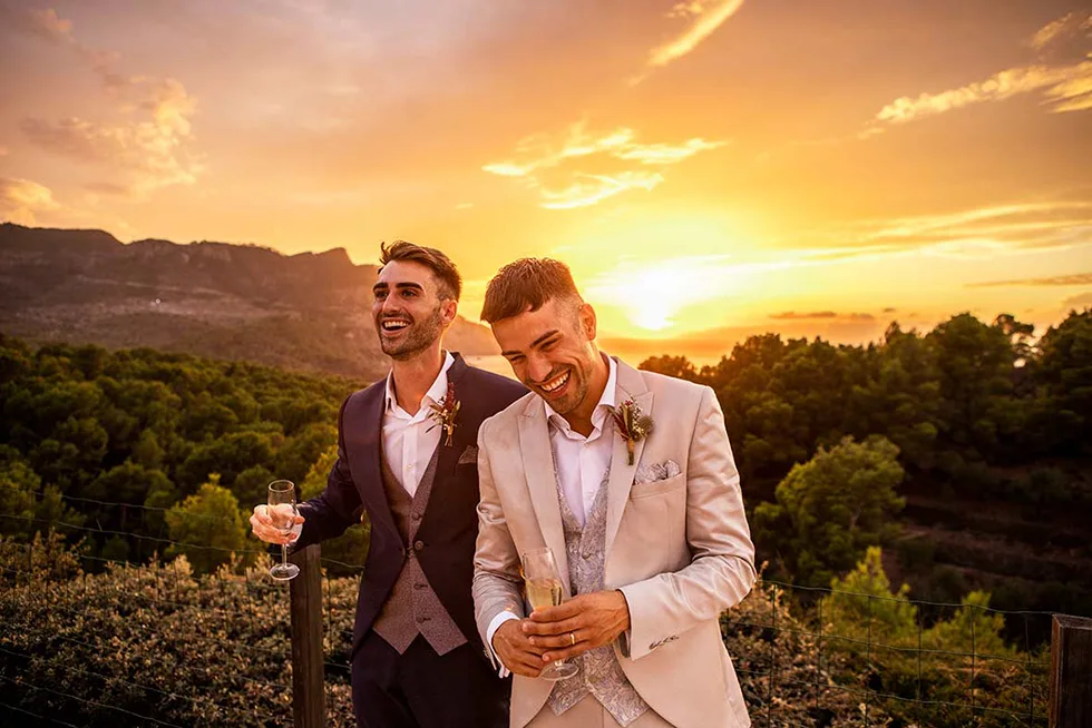 Pareja gay celebrando su boda de lujo al atardecer en Mallorca, fotografiada por Inma del Valle con un estilo romántico y elegante.