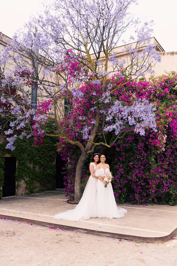 Bride standing under a blooming jacaranda tree in Mallorca – photo by Inma del Valle
