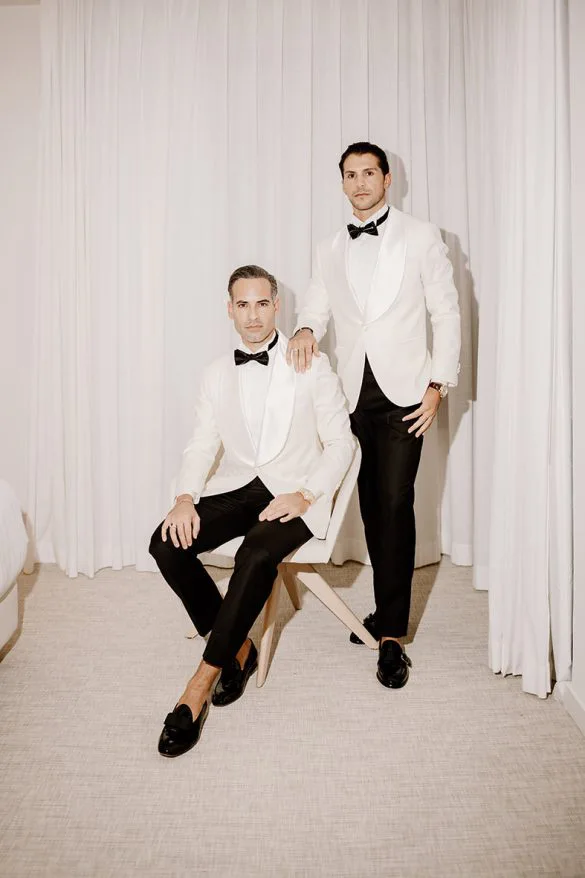 Pareja gay posando con esmoquin blanco antes de su boda de lujo en Mallorca, retrato elegante de Inma del Valle.