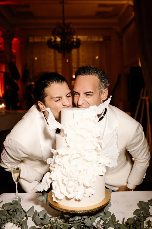 Pareja gay celebrando junto a su tarta nupcial en su boda de lujo en Mallorca, fotografía espontánea de Inma del Valle.