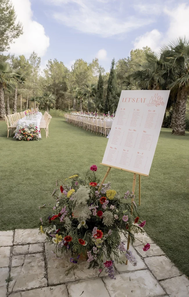Wedding seating plan at a luxury villa in Sitges, surrounded by flowers and greenery.