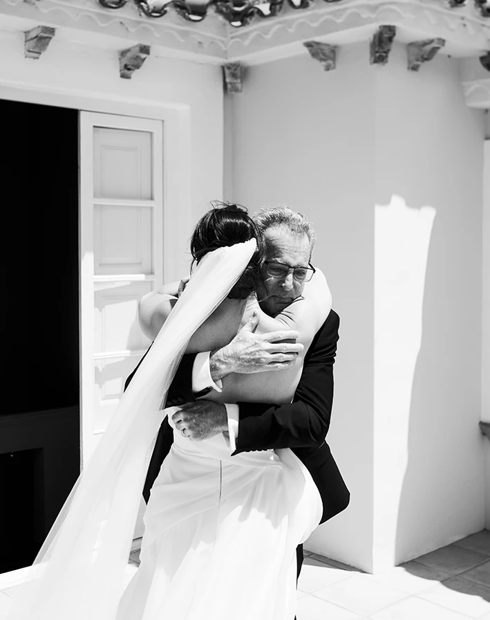 Emotional hug between bride and her father during their first look at a luxury villa in Sitges.