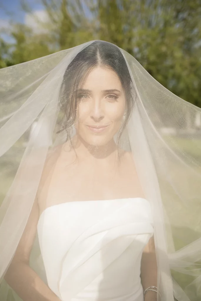 bride under veil looking at the camera during a luxury wedding in Sitges.