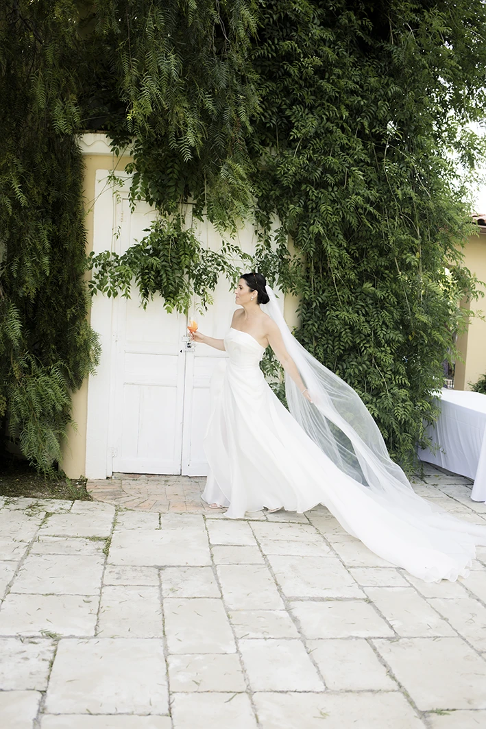 Elegant bride holding a glass of champagne during a luxury wedding in Sitges.