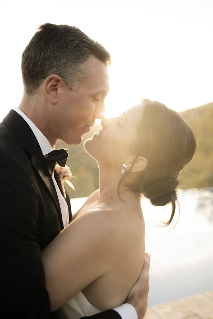 Romantic sunset kiss between the bride and groom at their luxury wedding in Sitges.
