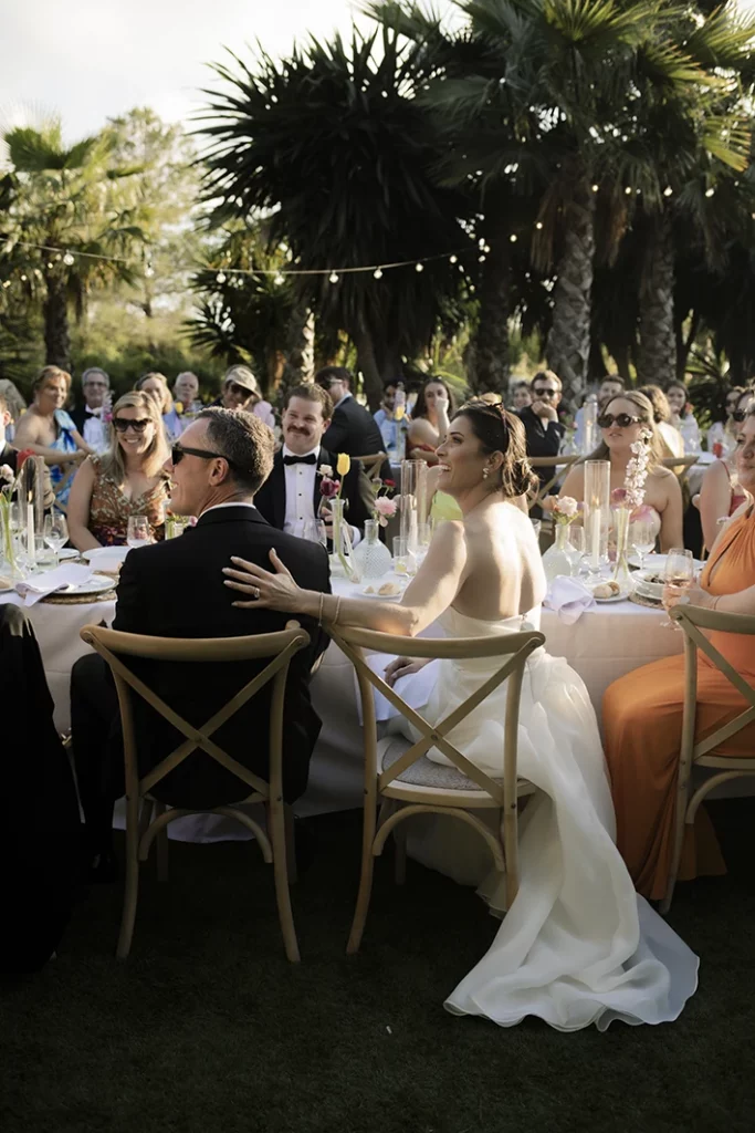 Bride Kendal sitting at a long table during a luxury wedding in Sitges.