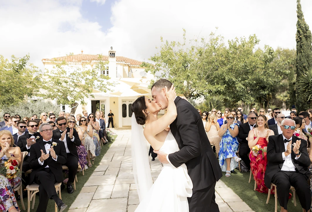 Bride and groom sharing their first kiss at a luxury wedding in Sitges.