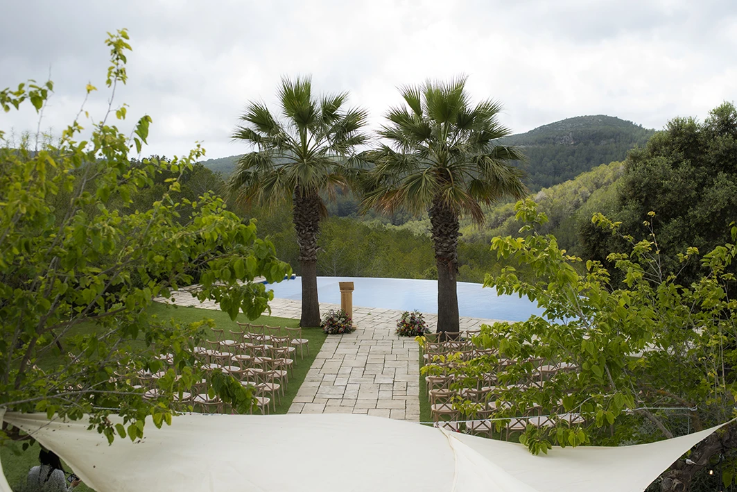 Ceremony setup for a luxury wedding in Sitges with mountain and palm tree views.