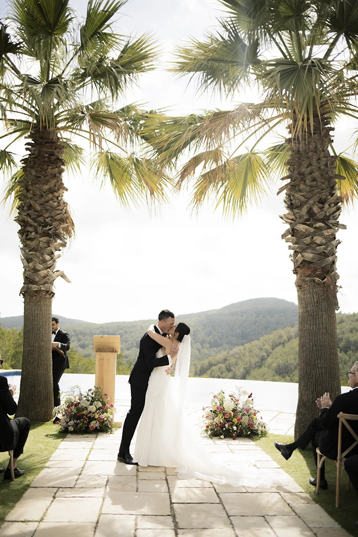Bride and groom's first kiss during their luxury wedding ceremony in Sitges.