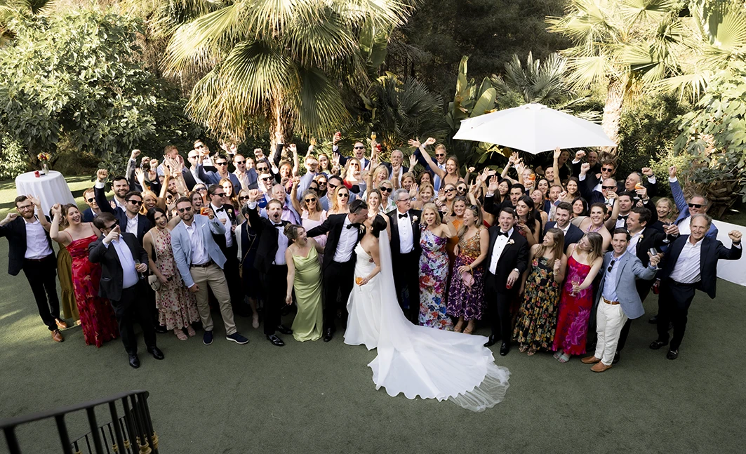 Wedding group photo in Sitges with the newlyweds surrounded by all their guests.