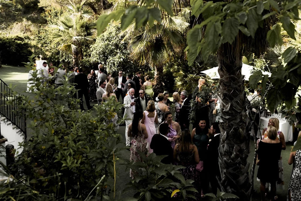 Guests walking through lush garden paths during a luxury wedding in Sitges.