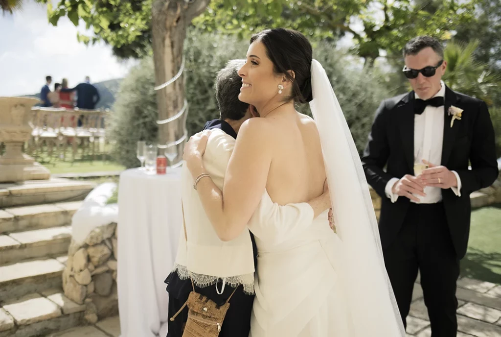 Bride warmly hugging a guest during a luxury wedding in Sitges.