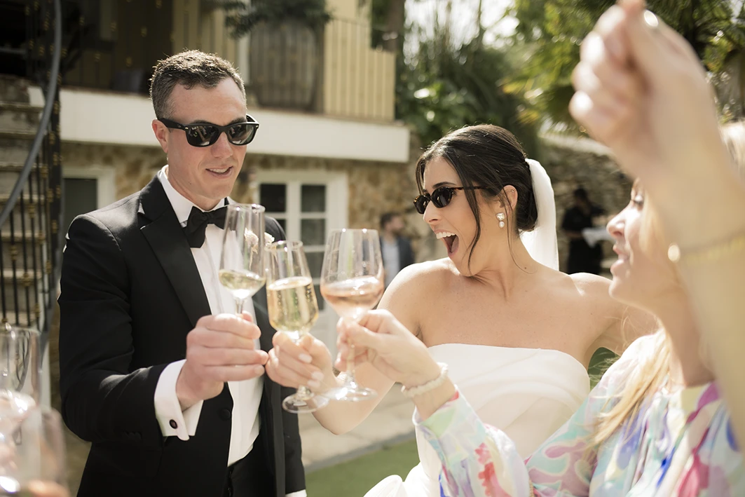 Bride and groom toasting with champagne during their luxury wedding in Sitges.