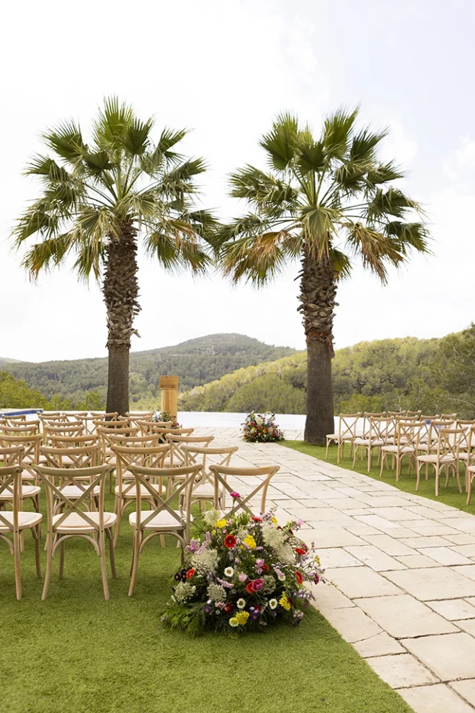 Outdoor ceremony setup with palm trees at a luxury wedding in Sitges.
