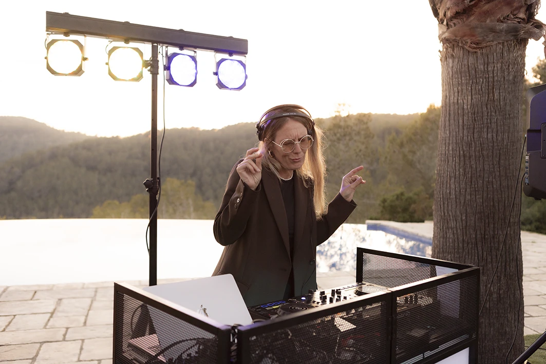 Female DJ playing at a luxury wedding in Sitges during sunset.