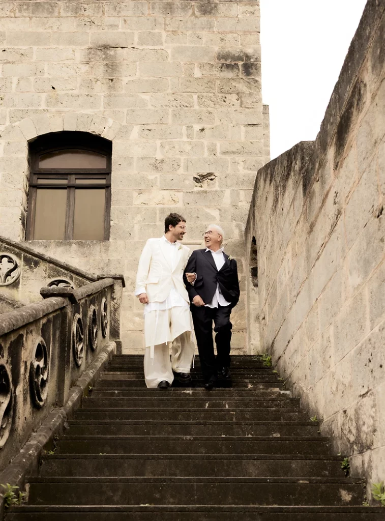 Novio bajando las escaleras con su padre en la boda en finca Gordiola Mallorca.