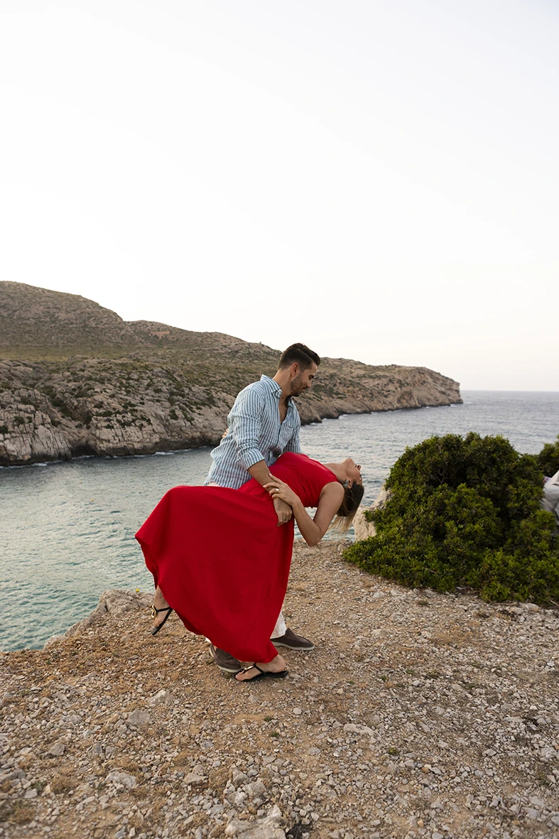 Couple dancing at the edge of a cliff during their surprise wedding proposal in Mallorca.