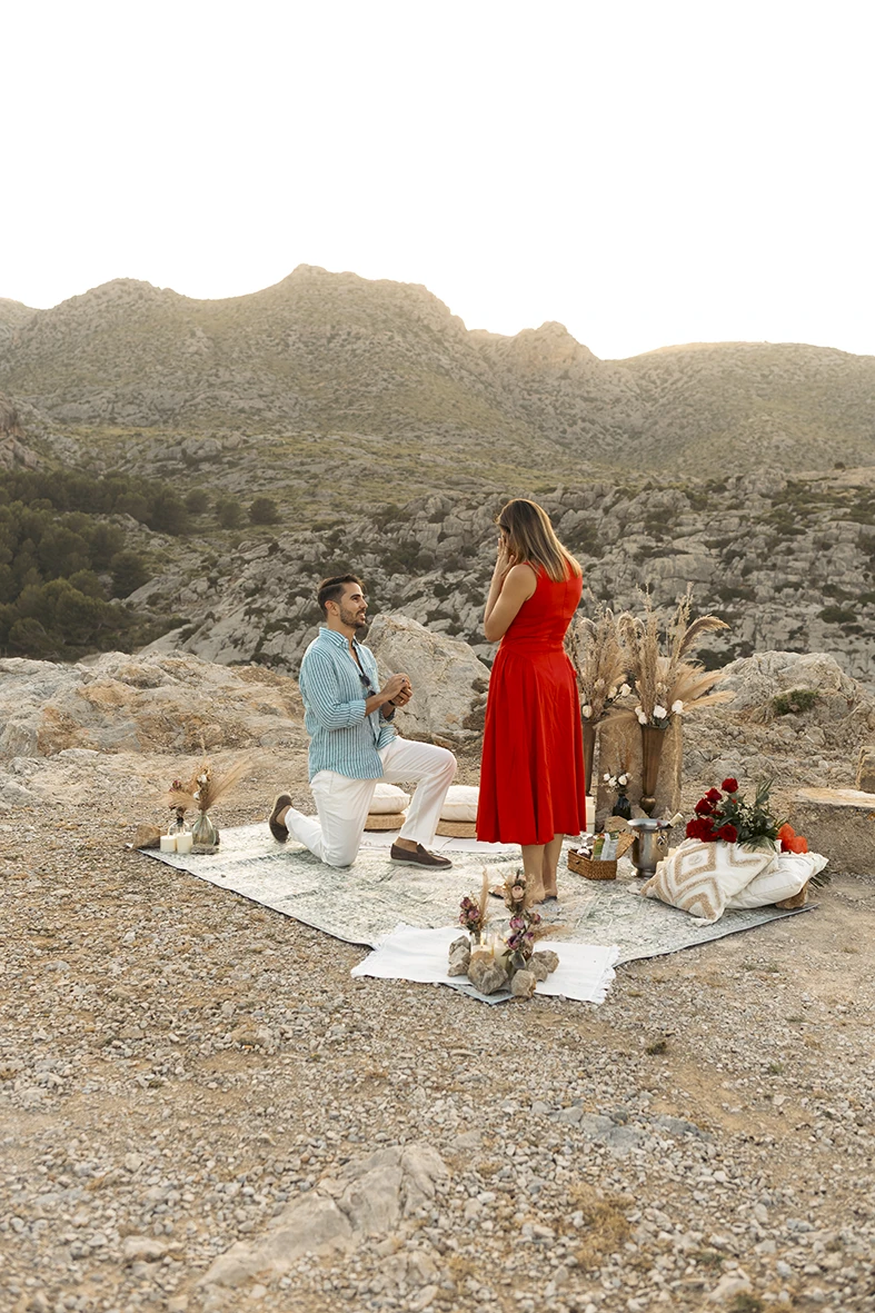 Surprise wedding proposal at sunset in Mallorca with romantic picnic setup in the mountains