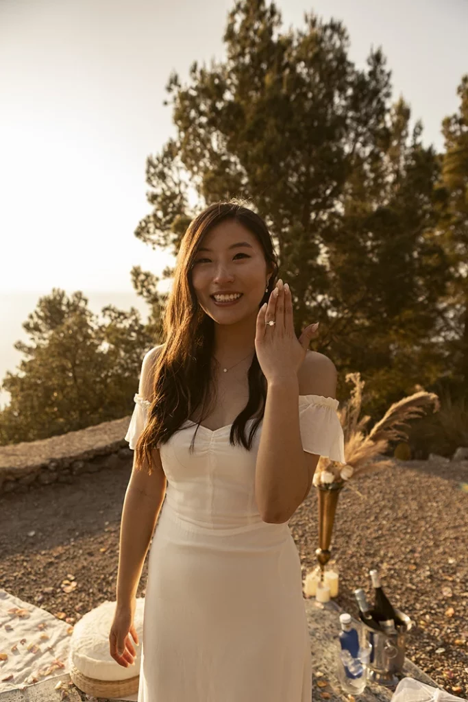 Bride-to-be showing engagement ring with joy at sunset in Mallorca.