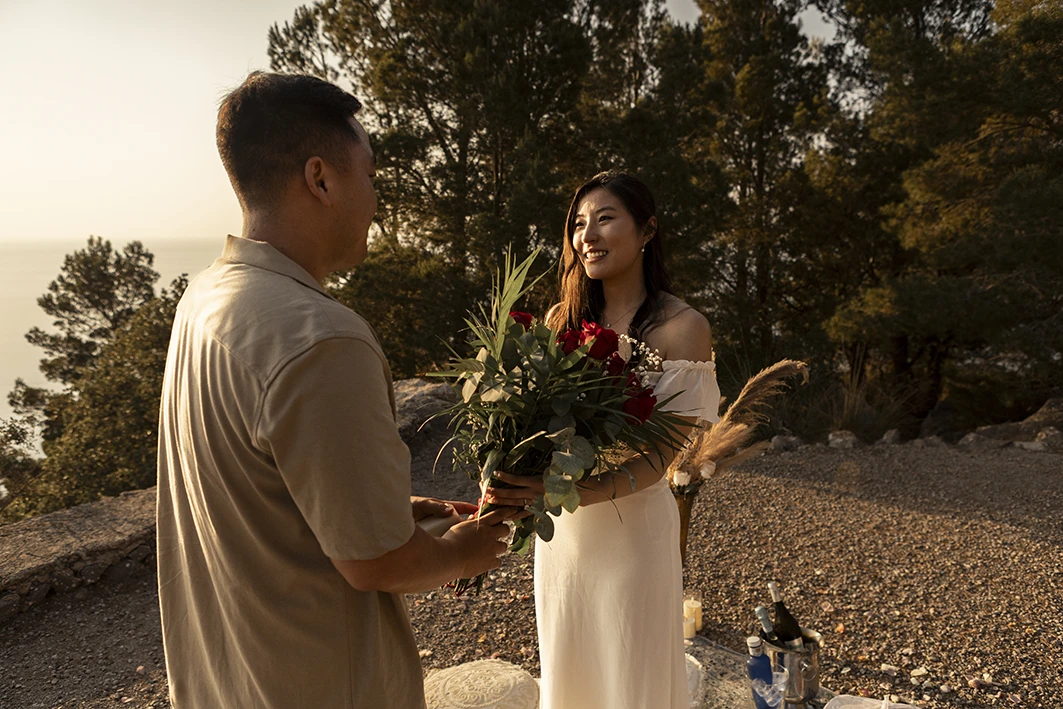 Man giving a bouquet of roses during a wedding proposal in Mallorca
