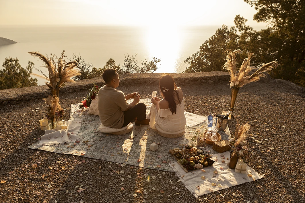 Couple enjoying sunset picnic during wedding proposal in Mallorca.