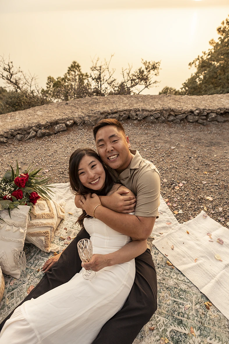 Couple hugging and smiling after wedding proposal in Mallorca.