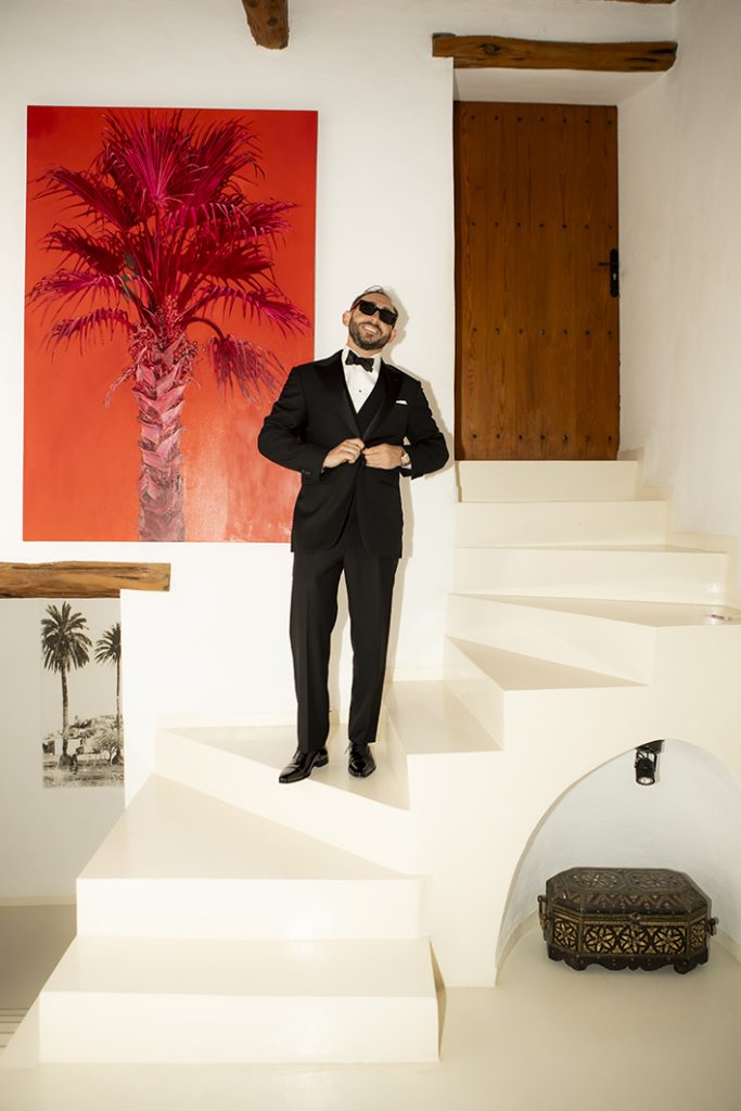 Kyle ajustando su pajarita en las escaleras de una villa de lujo en Ibiza antes de su boda, fotografiado por Inma del Valle.