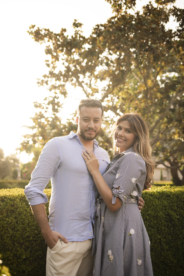 Couple smiling and relaxed in a Mallorcan garden during their pre-proposal photo session.