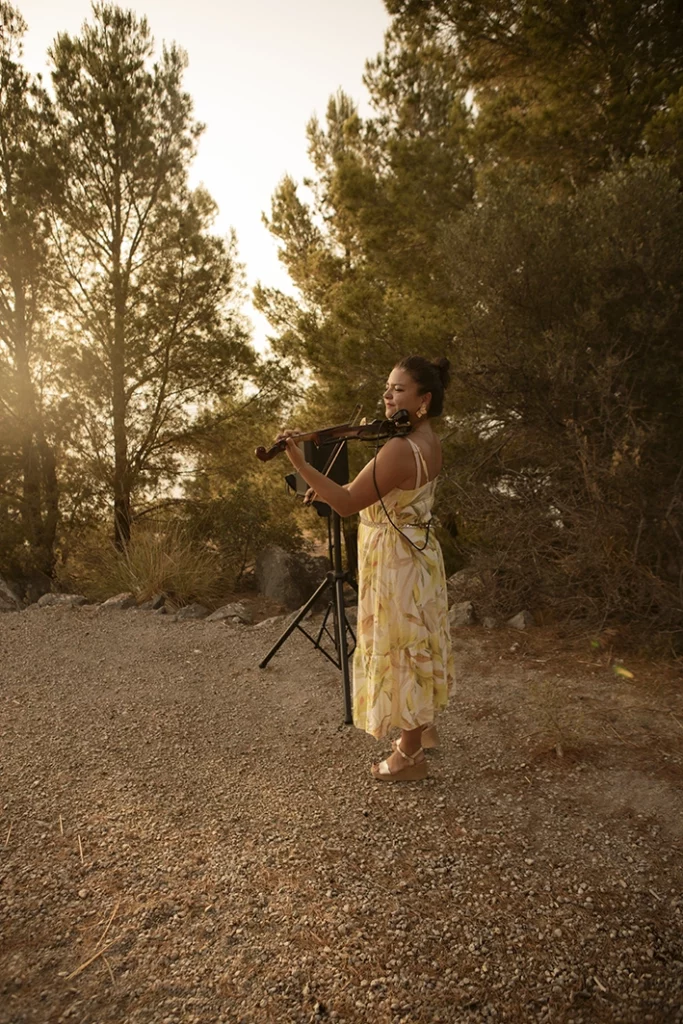 Violinist playing romantic music during a sunset proposal in Mallorca.