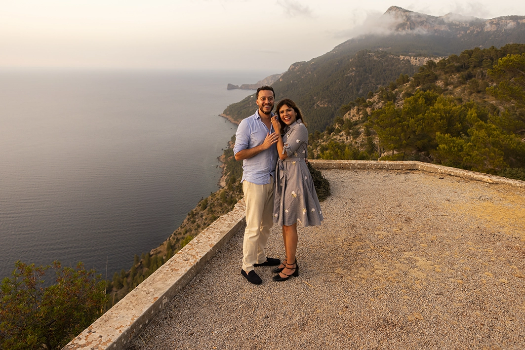Happy couple embracing by the sea after a proposal in Mallorca.