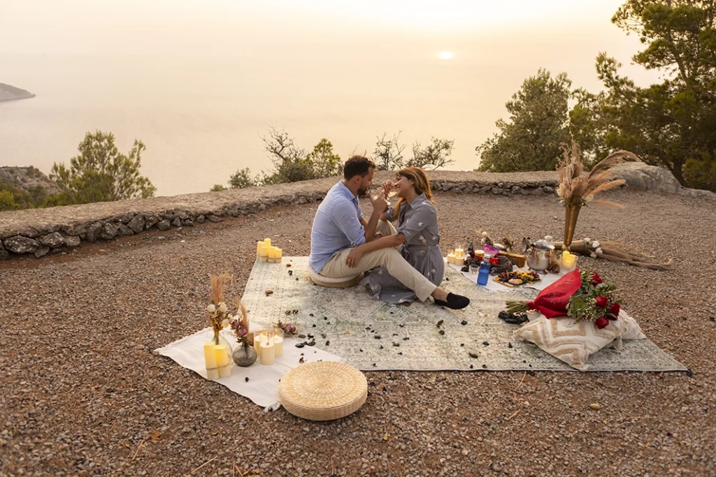 Couple gently touching each other during a romantic picnic after their proposal in Mallorca.