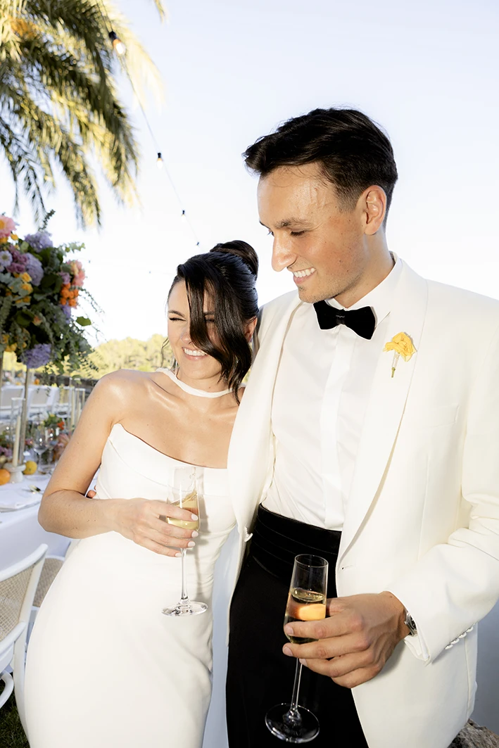 Lukas and Melissa smile happily with glasses in hand during their wedding at Son Togores Mallorca. Natural photography by Inma del Valle.