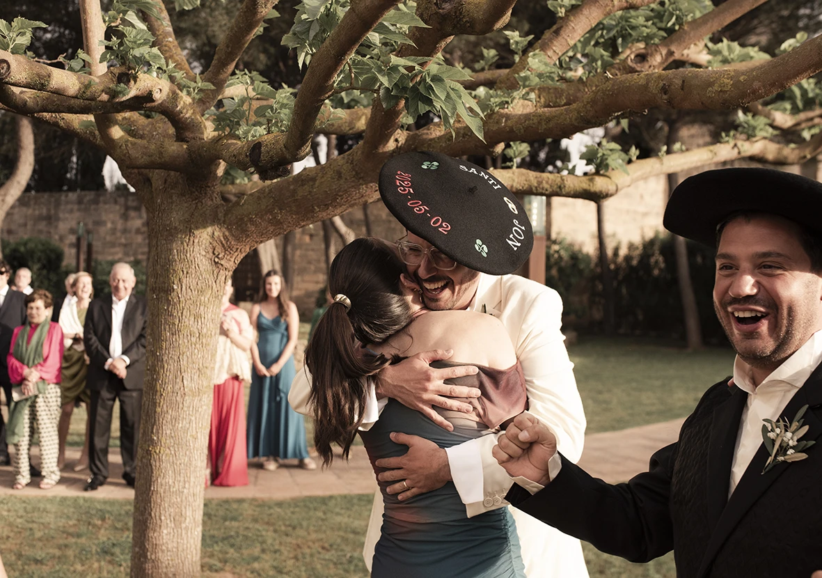 Jon hugging a guest while wearing a traditional Mexican sombrero during the wedding at Finca Gordiola.