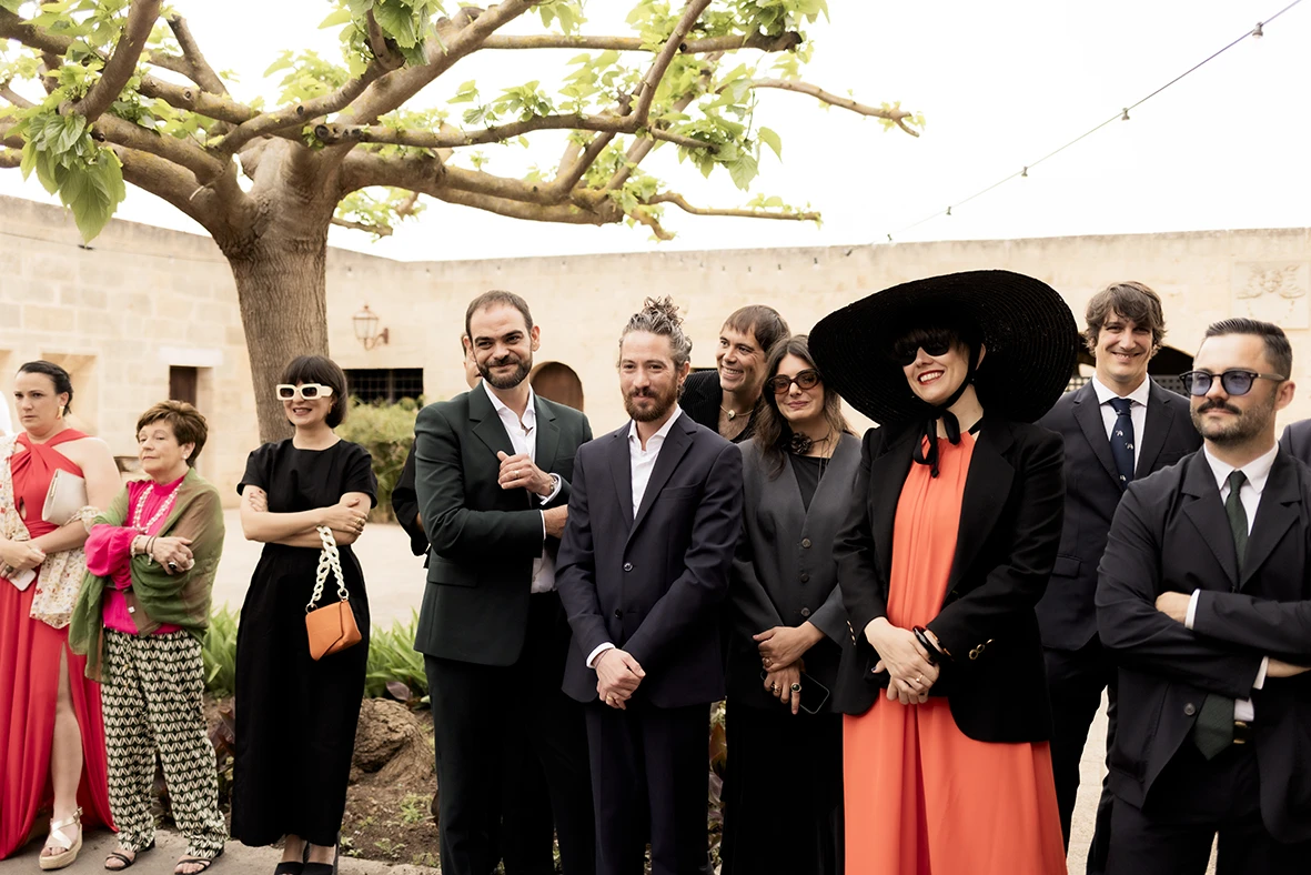 Wedding guests standing and smiling during the ceremony at Finca Gordiola, Mallorca.