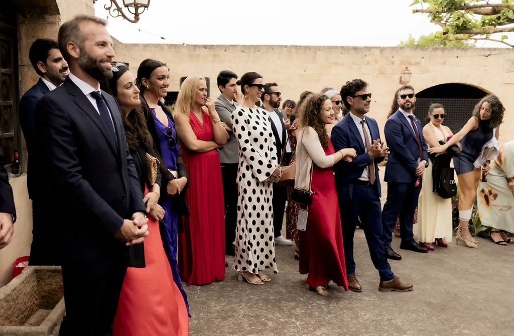 Wedding guests standing and watching the ceremony at Finca Gordiola, Mallorca.