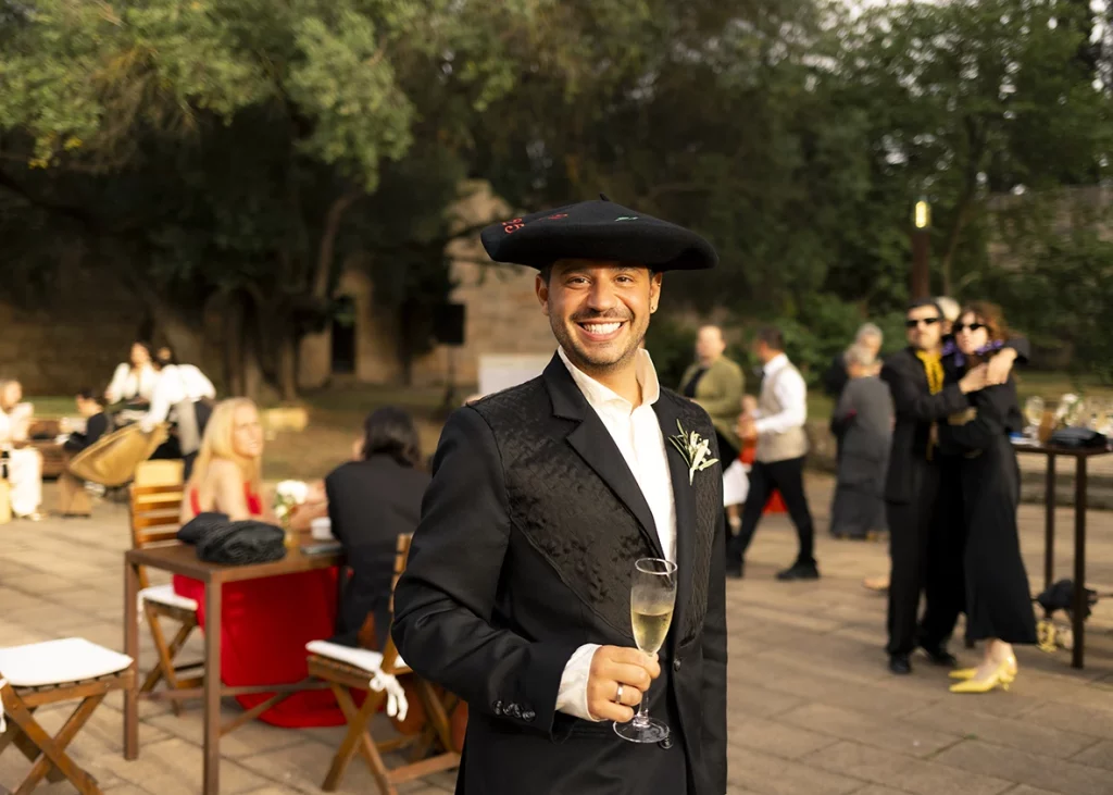 Groom smiling with a glass of champagne at his wedding in Mallorca.