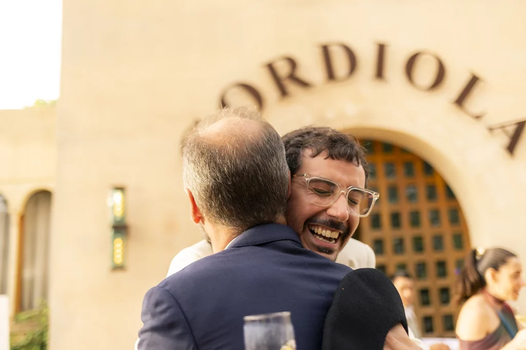 Groom smiling and hugging a guest at Finca Gordiola wedding.