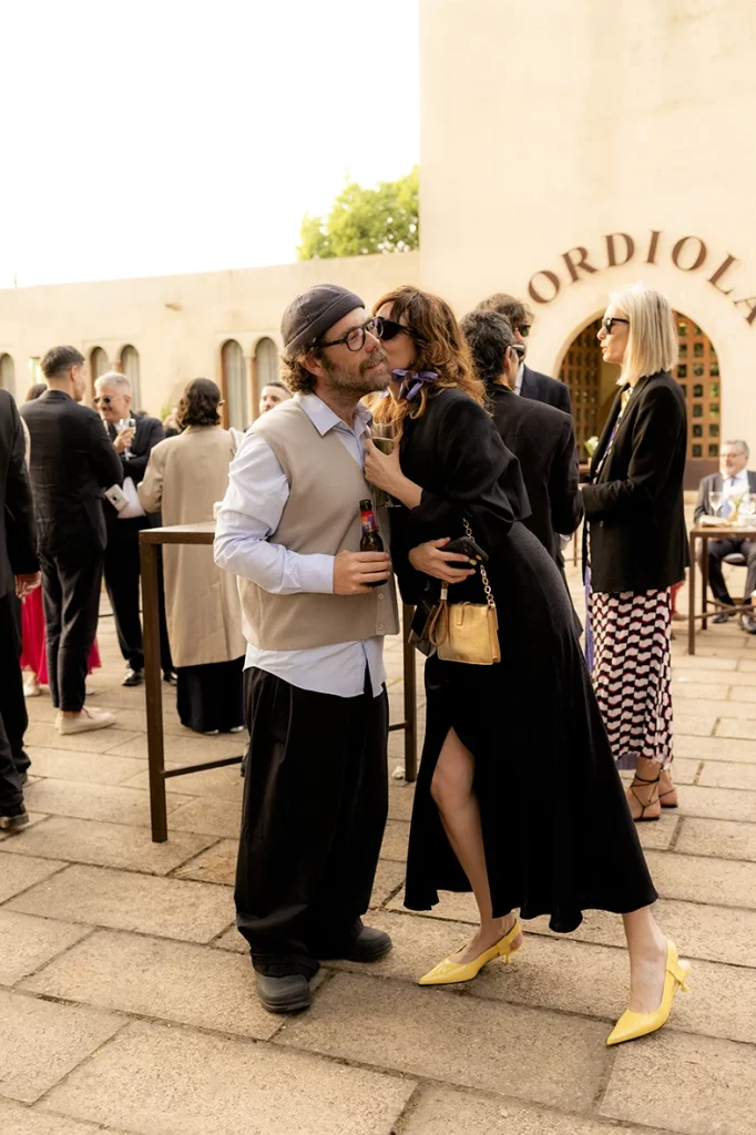 Wedding guests sharing a kiss during cocktail hour at Finca Gordiola in Mallorca.