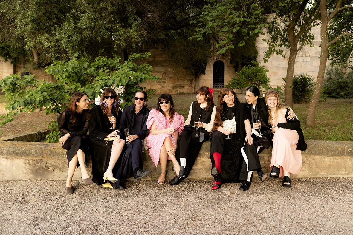 Group of stylish wedding guests sitting outdoors at Finca Gordiola in Mallorca.