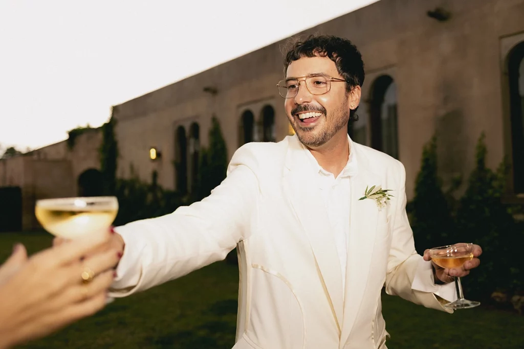 Jon toasting with a smile during his luxury wedding at Finca Gordiola Mallorca.