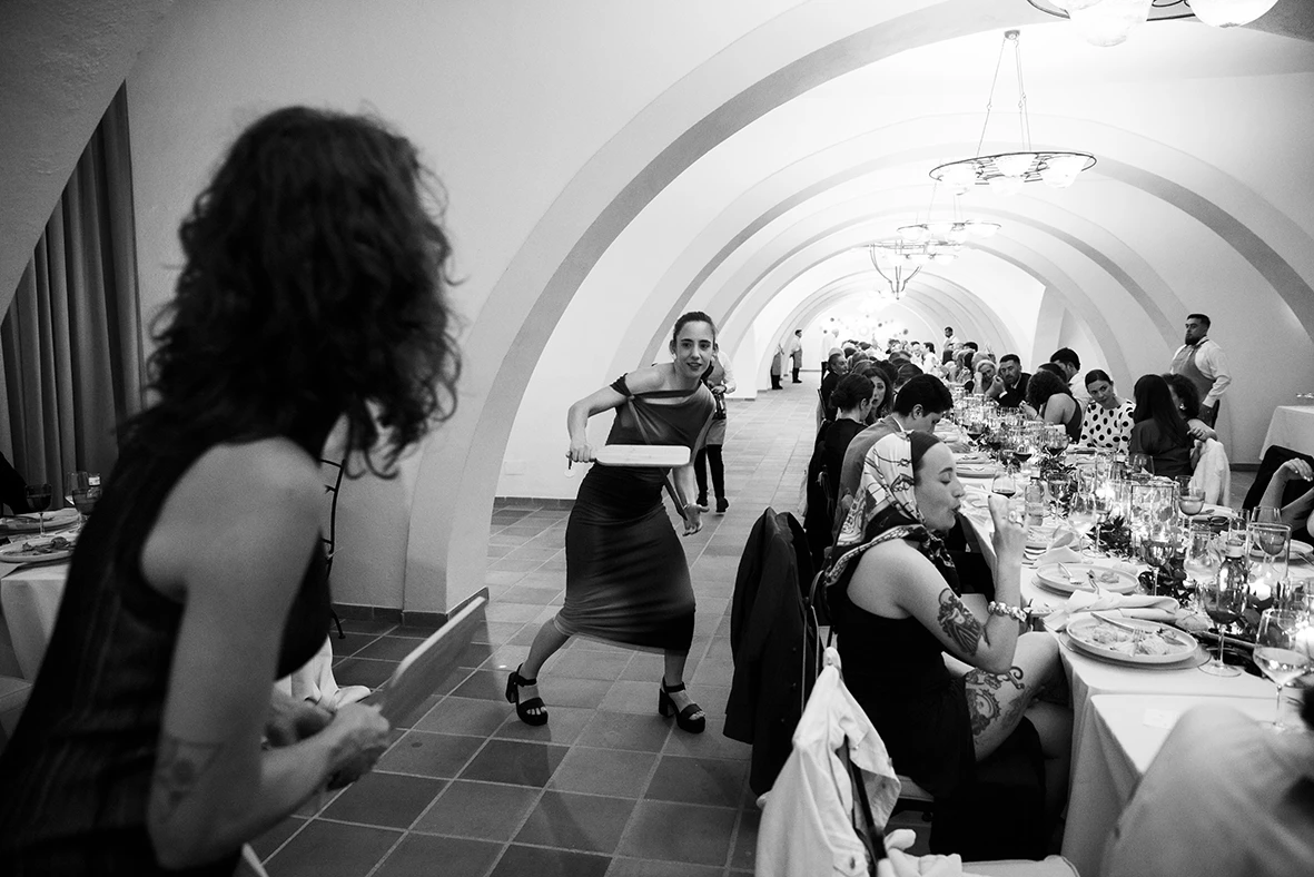 A guest carries a tray with a big smile during the wedding dinner at Finca Gordiola Mallorc