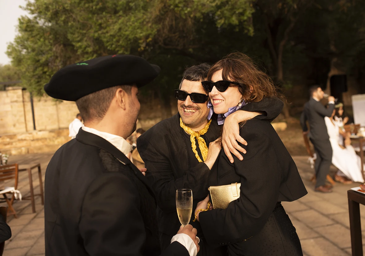 Guests hugging and celebrating with champagne at Jon and Santi’s wedding at Finca Gordiola.