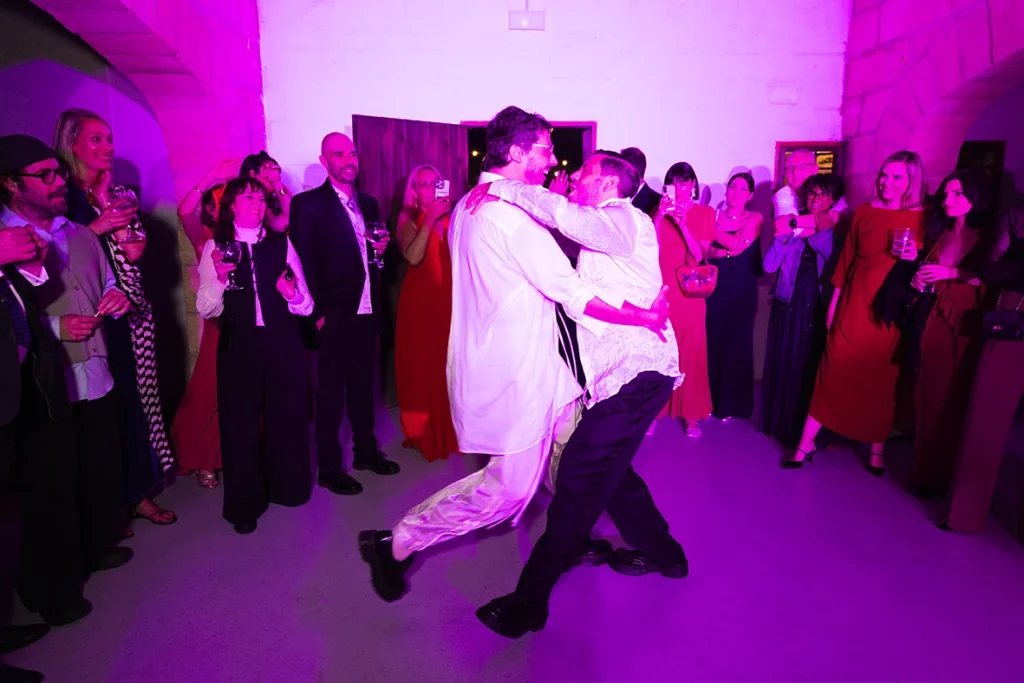 Jon and Santi dancing passionately surrounded by guests at their wedding at Finca Gordiola.